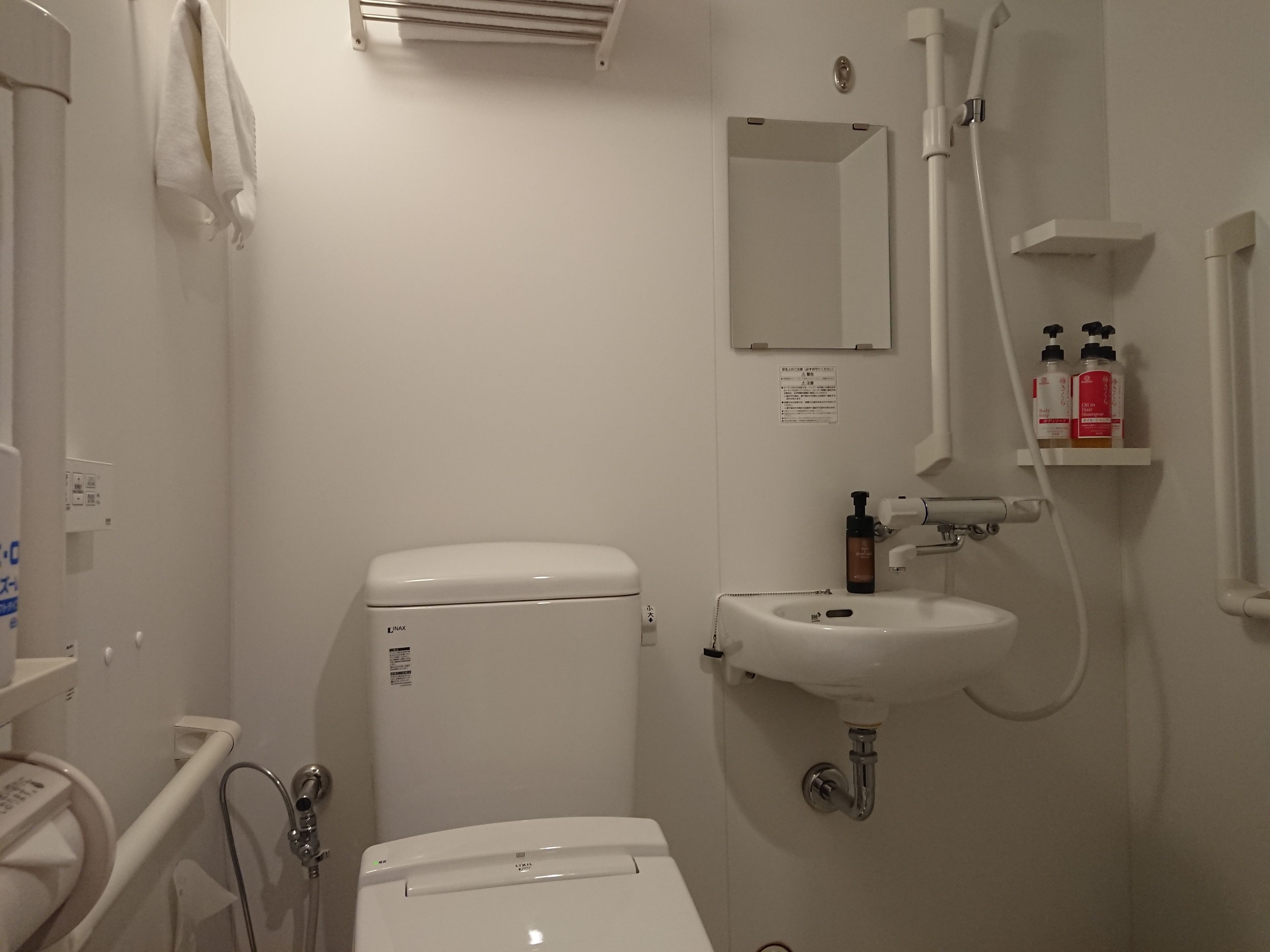 A small, clean bathroom with a toilet, sink, and shower.