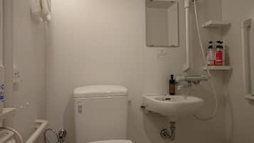 A small, clean bathroom with a toilet, sink, and shower.