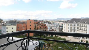 A balcony with a view of a cityscape, including various buildings and mountains in the distance. - Arapang Hotel 2 (Xuan Huong - Da Lat)