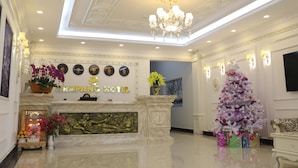 A hotel lobby with a reception desk, a chandelier, a Christmas tree, and a fireplace. - Arapang Hotel 2 (Xuan Huong - Da Lat)