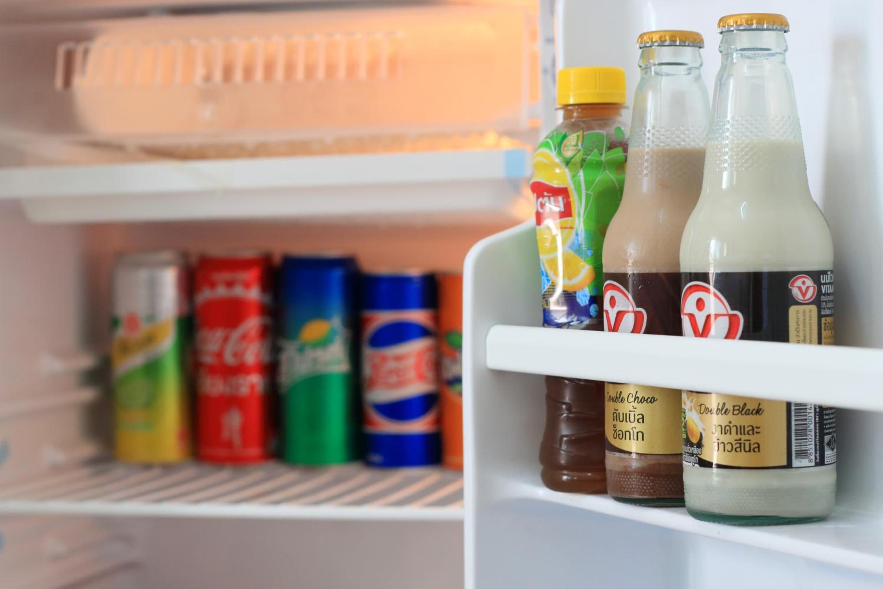 Un refrigerador con diversas bebidas y condimentos.