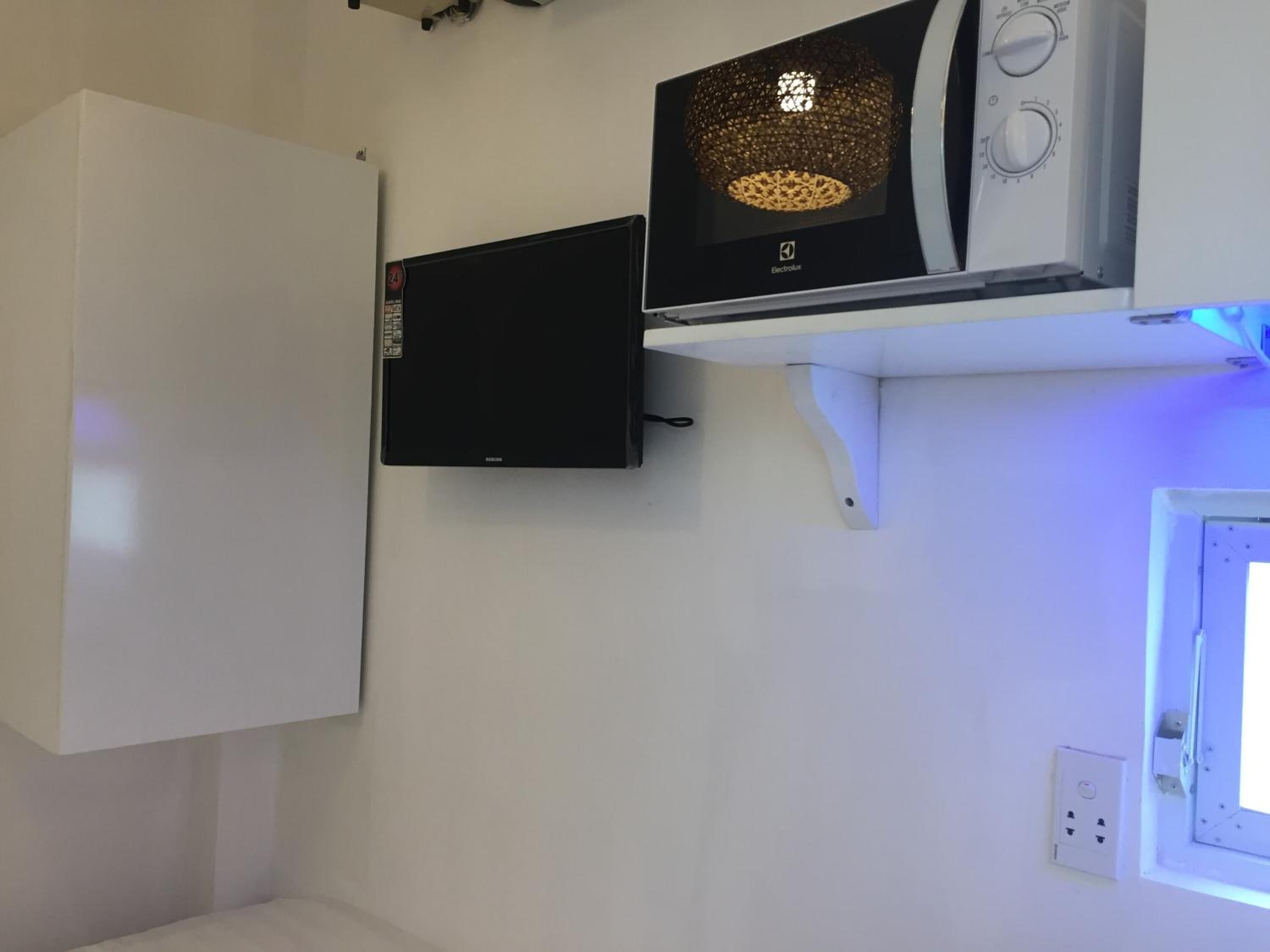 Una cocina con microondas, un electrodoméstico negro y una ventana con vistas.