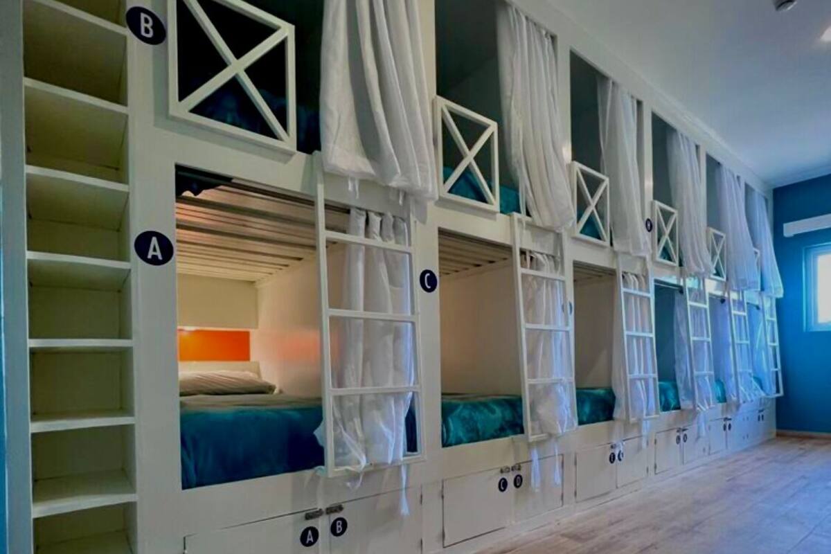 A row of bunk beds with individual storage compartments, each marked with a letter.