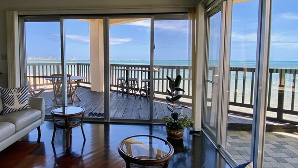 A spacious balcony with a wooden deck, furnished with a sofa, chairs, and a table. - Pontoon (Ishigaki)