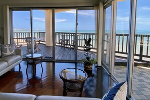 Ein geräumiger Balkon mit Holzterrasse, ausgestattet mit einer Couch, Stühlen und einem Tisch.