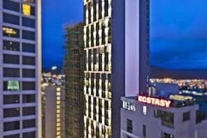 A multi-story building with a prominent 'ECSTASY' sign, surrounded by other high-rise structures. - Emerald Bay Hotel & Spa Nha Trang (Nha Trang)