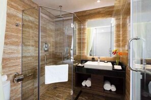 A modern bathroom with a glass-enclosed shower, a sink with a mirror, and a towel rack. - Emerald Bay Hotel & Spa Nha Trang (Nha Trang)