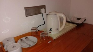 A kitchenette with a coffee maker, cups, and a tray. - Santon Resort & Spa (Kahandamodara)