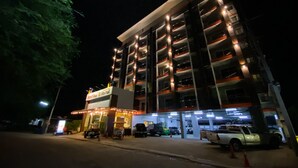 A multi-story hotel with illuminated balconies and a ground-level restaurant. - East Inn 15 Rayong (Rayong)