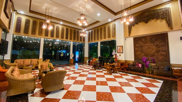 A lobby with checkered flooring, wicker furniture, hanging lights, and large windows. - East Inn 15 Rayong (Rayong)
