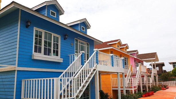 Una hilera de casas coloridas con barandillas blancas y escaleras que llevan a la entrada.