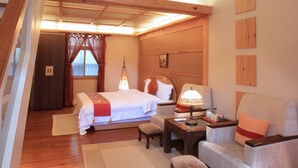 A bedroom with a bed, nightstand, chair, and a small table. - Country Grange (Yuanshan)