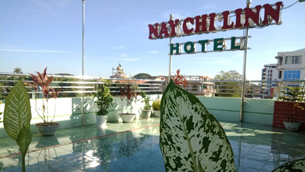 A rooftop garden with potted plants and a sign for Natchchilinn Hotel. - Nay Chi Linn Hotel (Pathein)