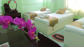 A hotel room with two beds, a small table, a mirror, and a window with curtains. - Nay Chi Linn Hotel (Pathein)