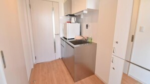 Eine kleine Küche mit Kühlschrank, Herd und Schränken.