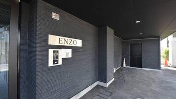 A modern building facade with the name "ENZO" prominently displayed.