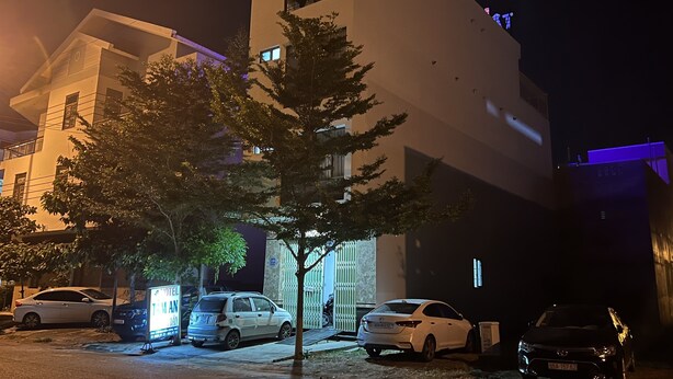 Ein mehrgeschossiges Gebäude mit einem Parkplatz davor.
