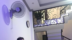Eine Hotelrezeption mit einem Holzboden, einer Uhr und einem Wandventilator.
