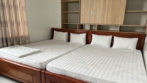 Ein Doppelbett mit Holzrahmen und Kopfteil, zwei Kissen und eine weiße Bettdecke.