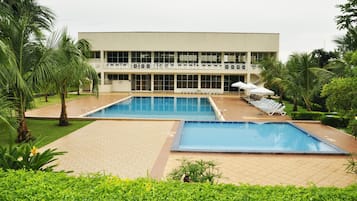 Relax by the pool surrounded by lush greenery and tropical plants.