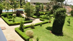 A well-maintained garden with a pool, neatly trimmed hedges, and a variety of trees. - Hotel Brovad Masaka (Masaka)