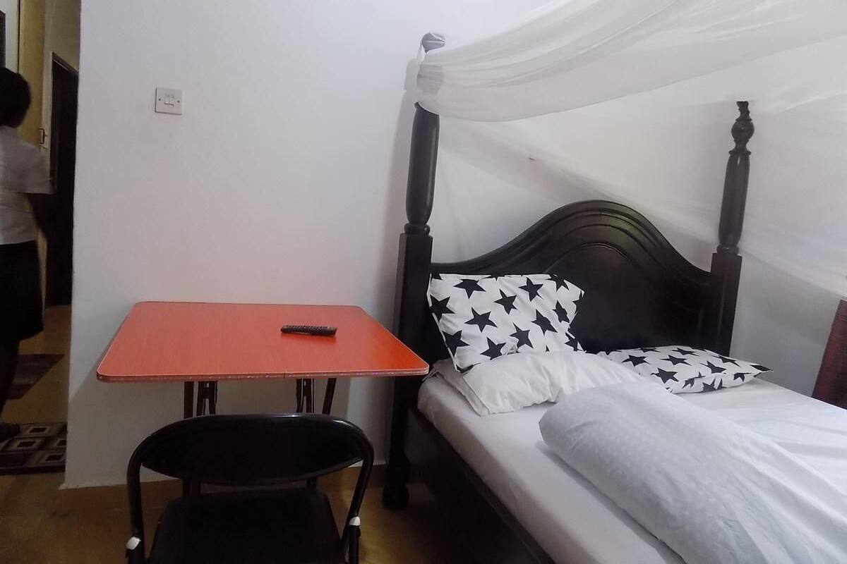 A room with a bed, a table, and a chair.
