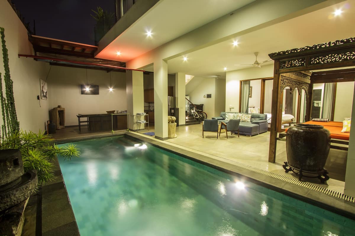 Une piscine avec un espace patio, une table à manger et un canapé.