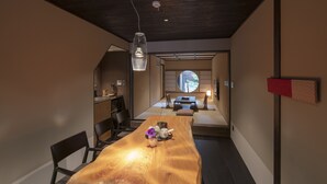 A modern interior with a wooden dining table, chairs, and a hanging light fixture. - Mimari (Kanazawa)