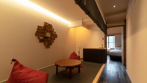 A traditional Japanese room with tatami flooring, a low wooden table, and red cushions. - Mimari (Kanazawa)