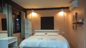 A neatly arranged bedroom with a bed, bedside tables, a wardrobe, and a trash bin. - Palio Home - Hostel (Ko Pha-ngan)