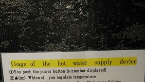 A hot water supply device with usage instructions in English and Japanese, including temperature regulation and safety warnings. - Mr KINJO in Nishihara Inter (Ginowan)