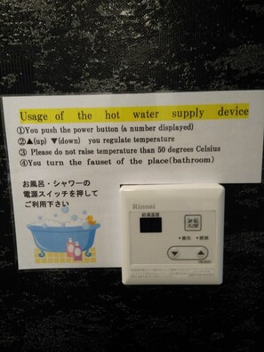A hot water supply device with usage instructions in English and Japanese, including temperature regulation and safety warnings. - Mr KINJO in Nishihara Inter (Ginowan)