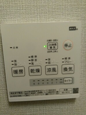 A control panel with buttons labeled in Japanese, including options for heating, drying, and air conditioning. - Mr KINJO in Nishihara Inter (Ginowan)