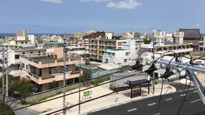 A cityscape with various buildings, including residential and commercial structures. - Mr KINJO in Nishihara Inter (Ginowan)