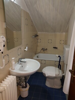 Une salle de bain avec un lavabo, des toilettes et une baignoire.