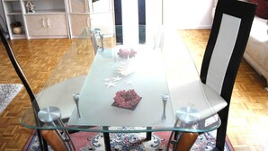 A dining area with a glass-top table, metal chairs, and a decorative centerpiece.