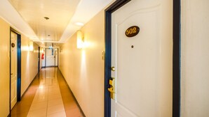 Un corridoio d'albergo con una porta contrassegnata dal numero 502 e un estintore appeso al muro.