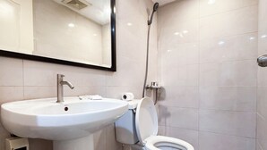 Un bagno moderno con lavabo su piedistallo, WC e doccia.