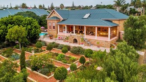 A large, two-story building with a covered patio area and a swimming pool. - Bettys Boutique Hotel (Mossel Bay)