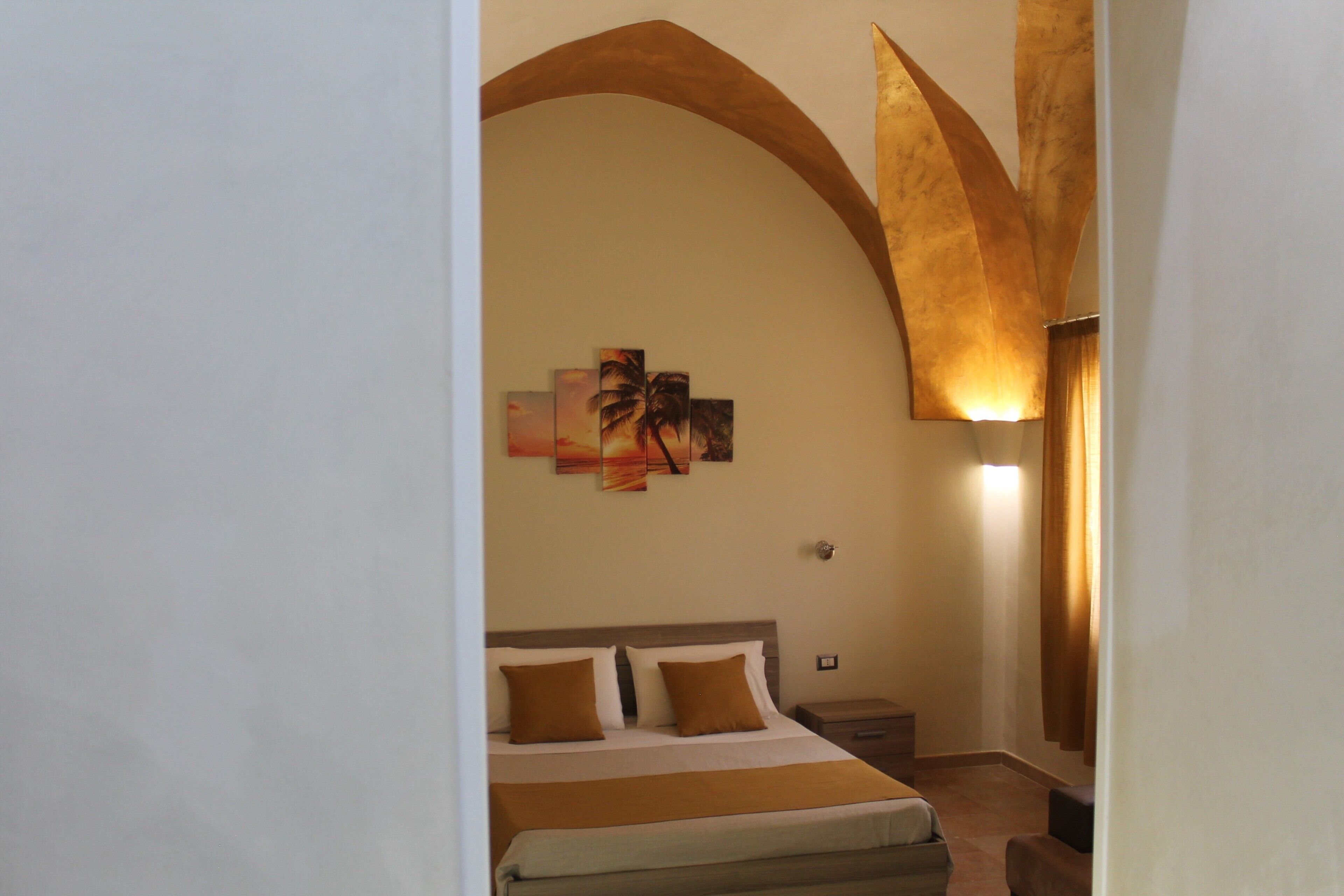 Ein Hotelzimmer mit einem Bett, einem Nachttisch und einem an der Wand hängenden Kunstwerk.