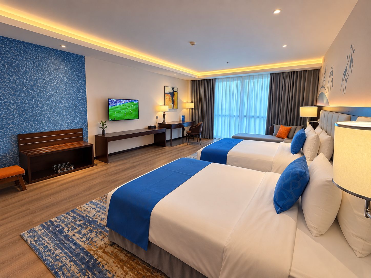 Habitación de hotel con dos camas, un escritorio, un televisor y una zona de estar.