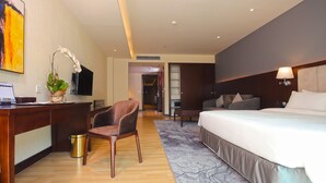 Een hotelkamer met een bed, bureau, stoel en een televisie.