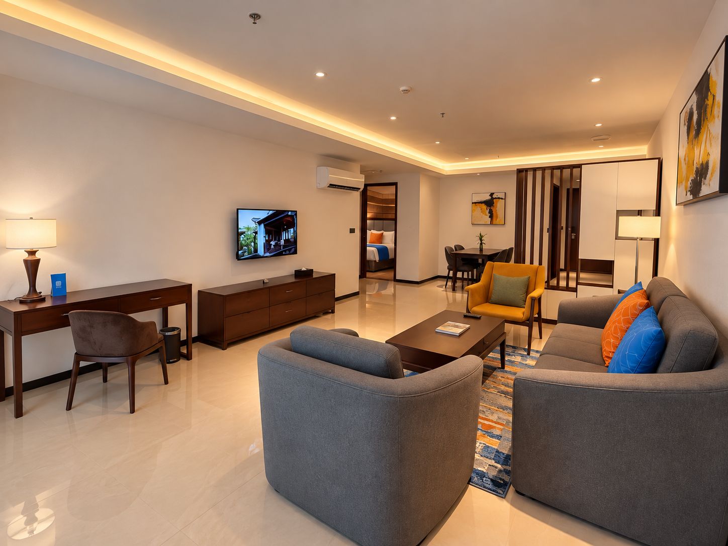 A modern living room with a flat-screen TV, a sofa, a coffee table, and a dining area with a table and chairs.