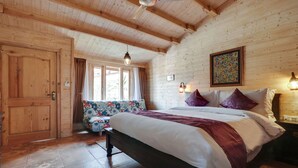 A wooden room with a bed, a bench, and a window. - Treebo Premium Blue Mountain Country Club And Resort (Siliguri)