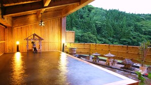 A wooden interior with a hot spring area, wooden benches, a small shrine, and a view of a forested hillside. - Tsuchiyu Onsen MUKAITAKI (Fukushima)