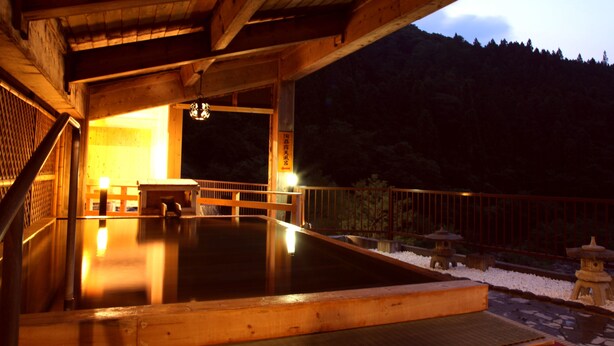 A wooden structure with a hot spring area, wooden railings, and stone lanterns. - Tsuchiyu Onsen MUKAITAKI (Fukushima)