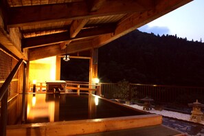 A wooden structure with a hot spring area, wooden railings, and stone lanterns. - Tsuchiyu Onsen MUKAITAKI (Fukushima)