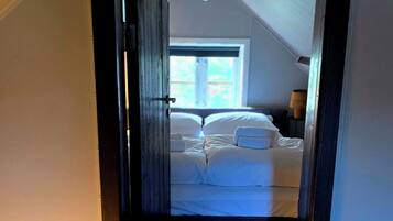 A room with a bed, a lamp, and a window.