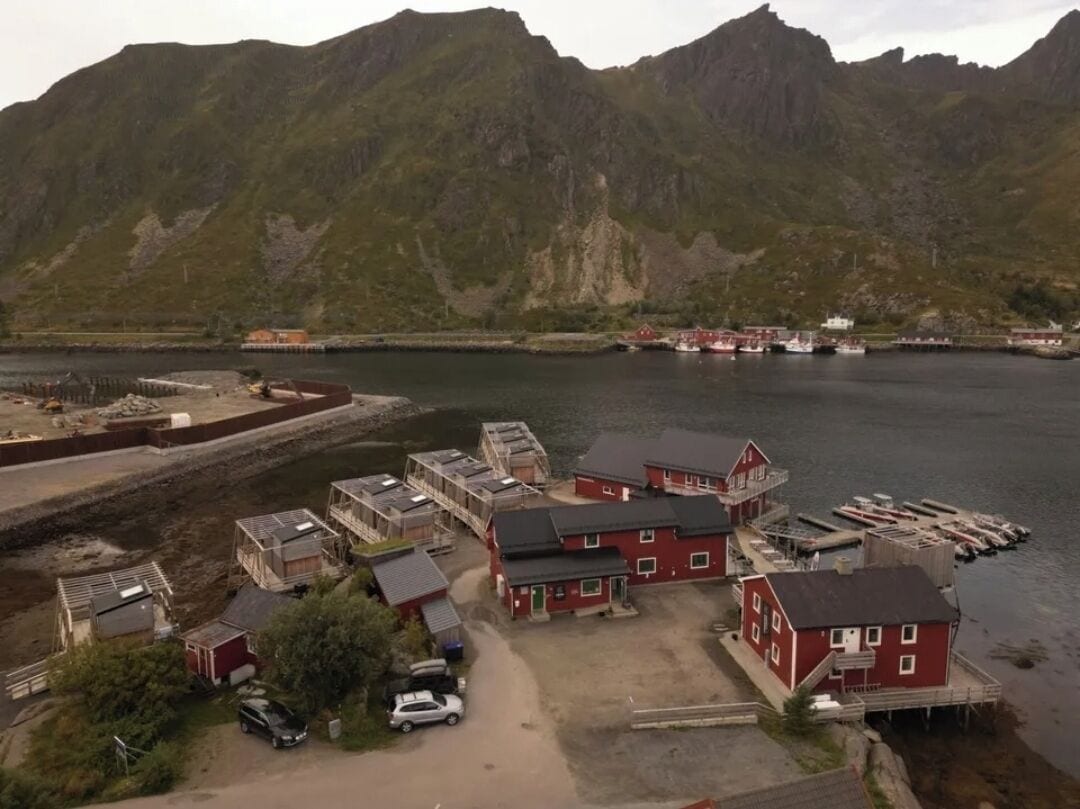 A coastal village with red buildings, a dock, and boats.