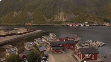A coastal village with red buildings, a dock, and boats.